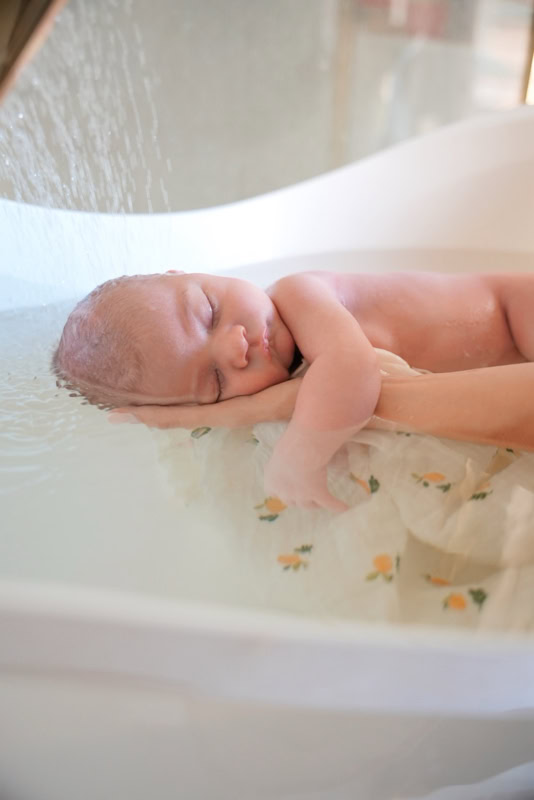 Nouveau-né dans le bain thérapeutique, mains de Caroline